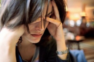 Woman holding her head, looking stressed.